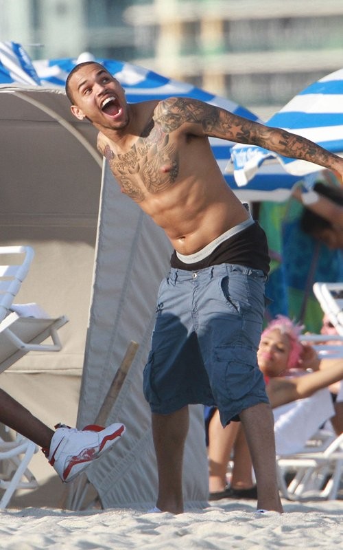 Chris Brown "quậy" hết sức cùng bạn bè trên bờ biển đầy nắng Miami. Anh cởi trần và mặc quần ngắn màu xanh, để lộ khá rõ quần trong màu đen - xu hướng đã trở nên quá quen thuộc.